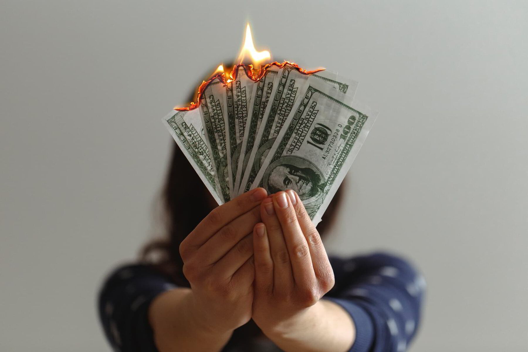 Woman burning US dollars on her energy bill